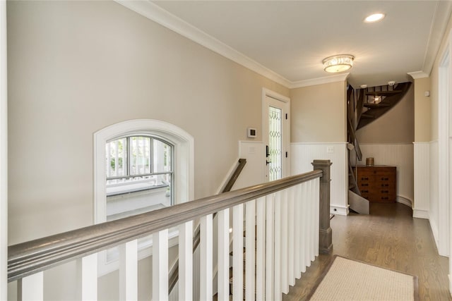 hall with crown molding, wood finished floors, a wainscoted wall, an upstairs landing, and recessed lighting