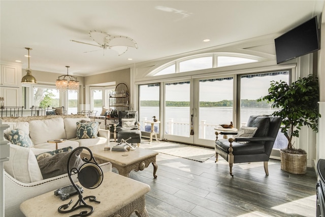 living room featuring french doors, light wood finished floors, a chandelier, ornamental molding, and recessed lighting