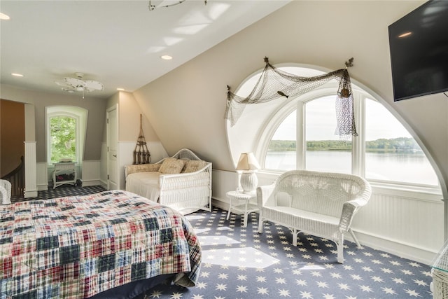 bedroom featuring wainscoting, a water view, and carpet flooring