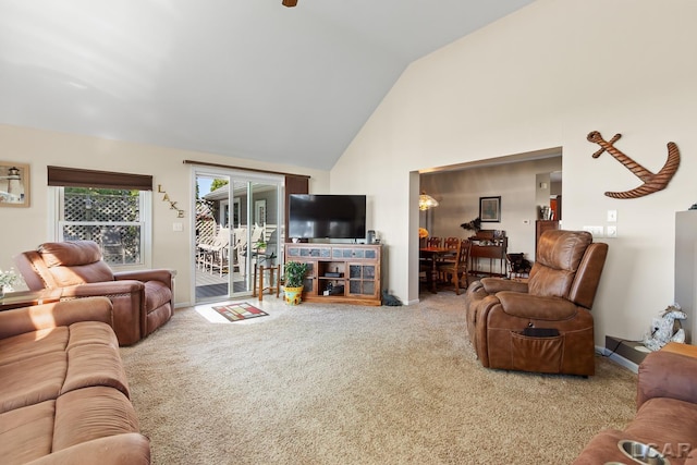 carpeted living area with high vaulted ceiling and baseboards