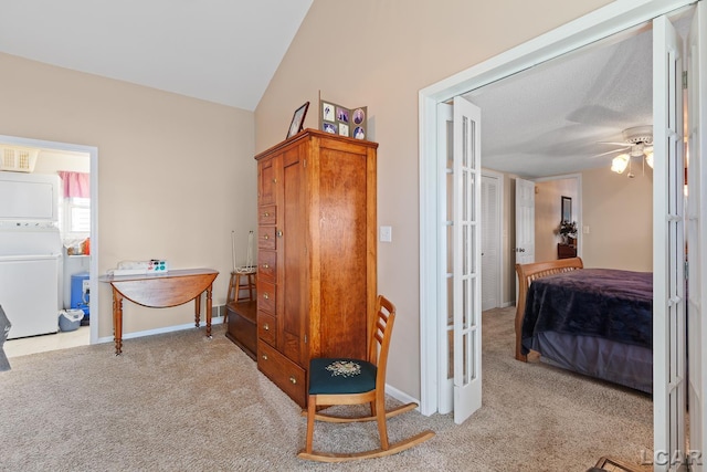 hall featuring baseboards, carpet, stacked washing maching and dryer, and vaulted ceiling