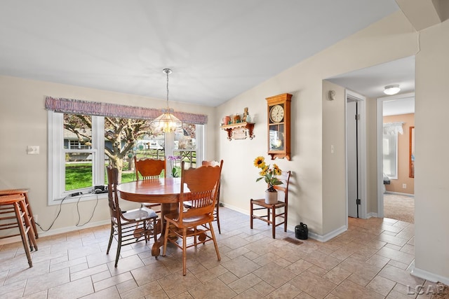 dining space featuring an inviting chandelier, baseboards, stone finish floor, and visible vents