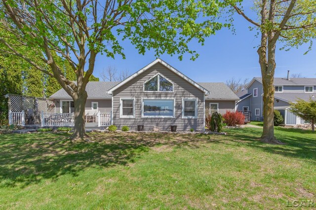 rear view of property with a lawn and a wooden deck