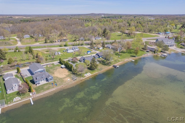 drone / aerial view featuring a residential view, a water view, and a wooded view