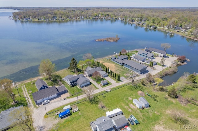 drone / aerial view featuring a forest view, a residential view, and a water view