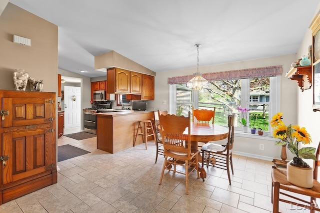 dining space with baseboards, a notable chandelier, and stone tile flooring