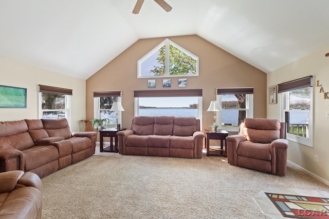 living room with high vaulted ceiling, ceiling fan, light carpet, and a water view