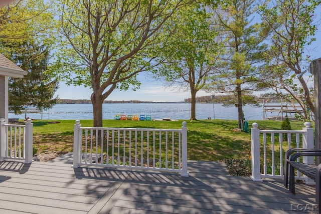 deck with a lawn and a water view