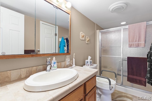 bathroom with vanity, a shower stall, and toilet