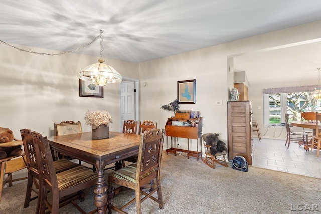 carpeted dining space with baseboards, tile patterned flooring, and a chandelier
