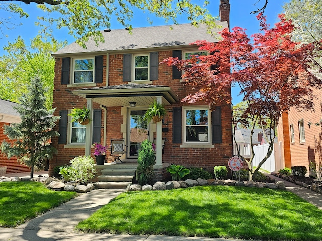 1732 14th St, Wyandotte, MI 48192 - view of front of property with brick siding, a chimney, a front lawn, and a porch