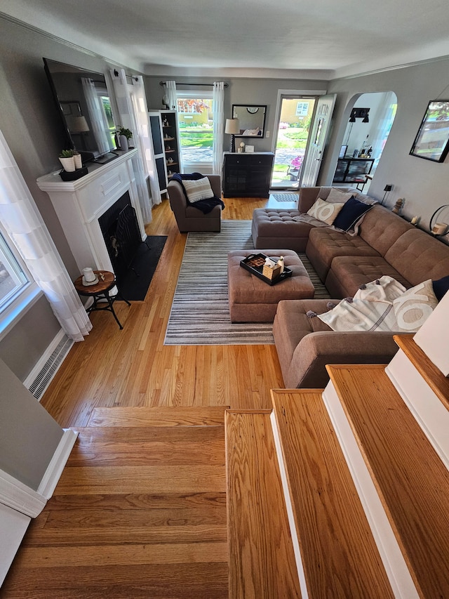 1732 14th St, Wyandotte, MI 48192 - living area featuring light wood finished floors, arched walkways, and a fireplace with flush hearth