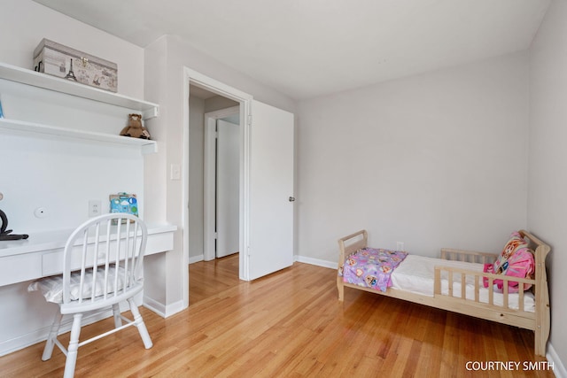 bedroom with baseboards and wood finished floors
