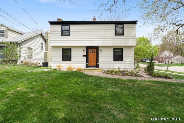 colonial house with central AC unit, a chimney, and a front lawn