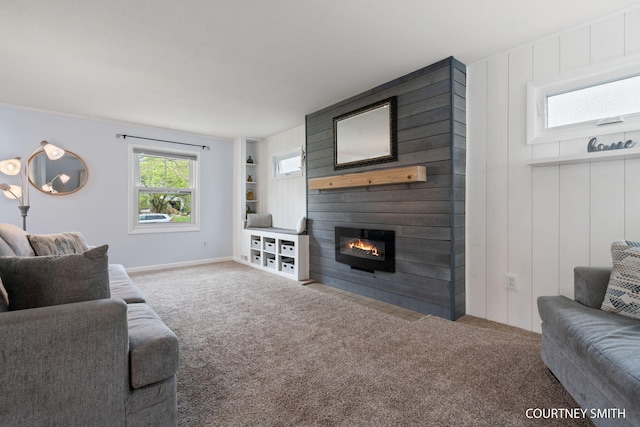 carpeted living room with baseboards and a large fireplace