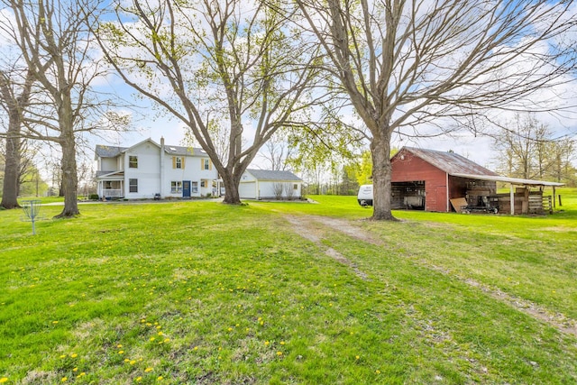 view of yard featuring a detached garage and an outbuilding