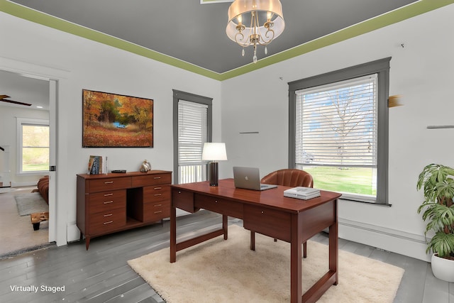 office area featuring a notable chandelier, a baseboard heating unit, and light wood-style flooring