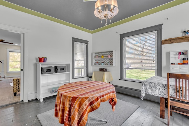 dining area with baseboards, a chandelier, and hardwood / wood-style floors