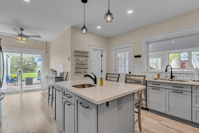 kitchen featuring a sink, gray cabinetry, and a wealth of natural light