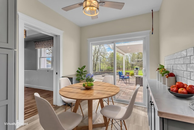 dining room with light wood finished floors, ceiling fan, and a wealth of natural light