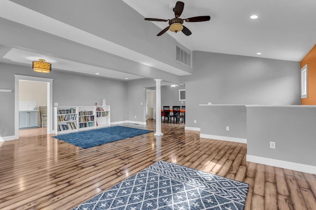 interior space with visible vents, decorative columns, wood finished floors, baseboards, and ceiling fan