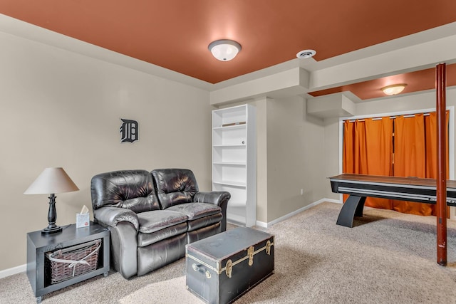 carpeted living area featuring baseboards