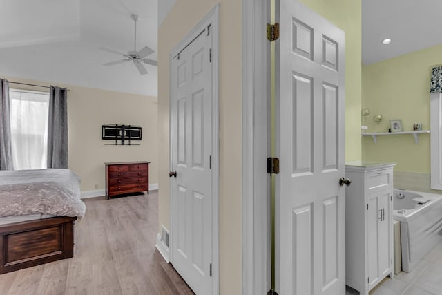 interior space with light wood-style floors, baseboards, and lofted ceiling