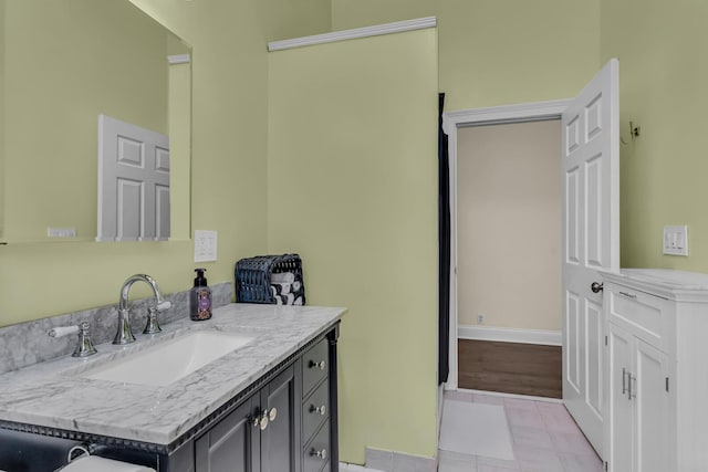 bathroom featuring vanity, baseboards, and tile patterned flooring