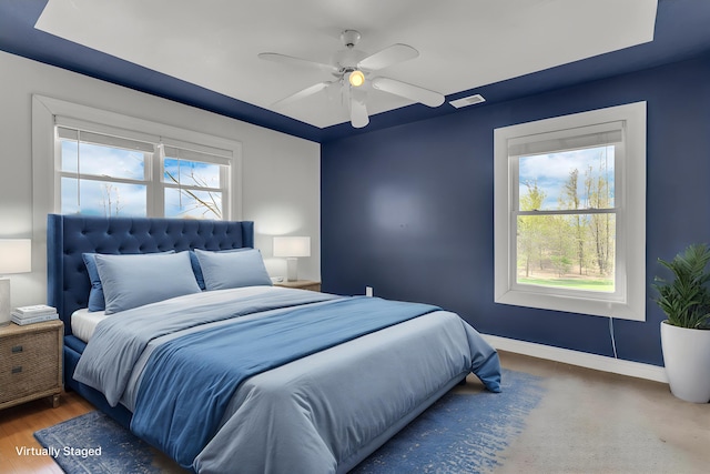 bedroom featuring baseboards, multiple windows, and ceiling fan