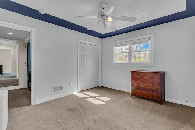 unfurnished bedroom with baseboards, carpet, a closet, and visible vents