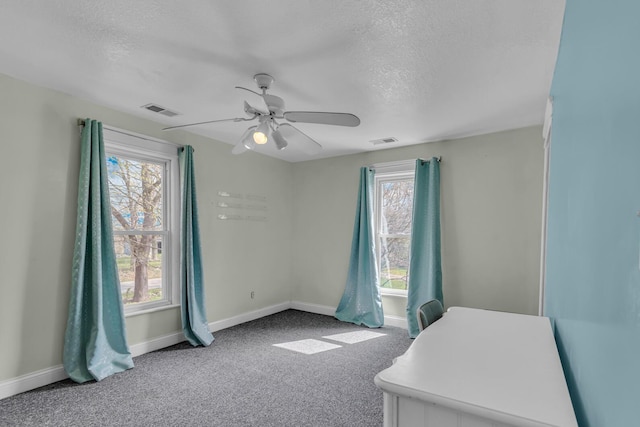 unfurnished bedroom with a textured ceiling, visible vents, and carpet