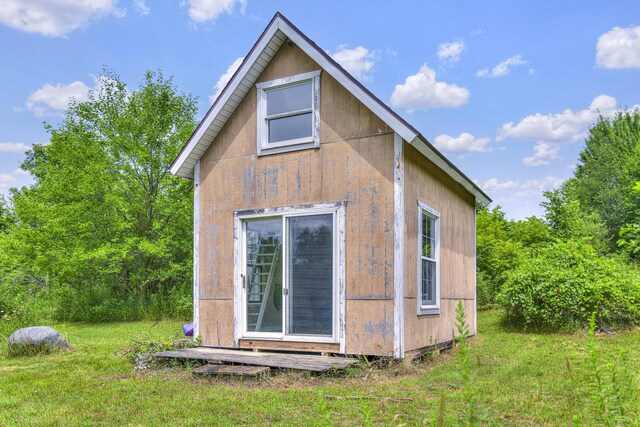view of property exterior featuring an outdoor structure and a yard