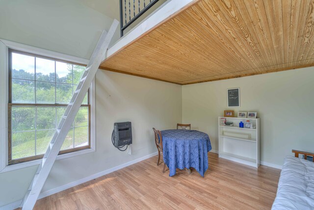 bedroom with baseboards, multiple windows, wood ceiling, and light wood finished floors