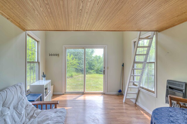 sitting room featuring baseboards, heating unit, wood finished floors, and wooden ceiling