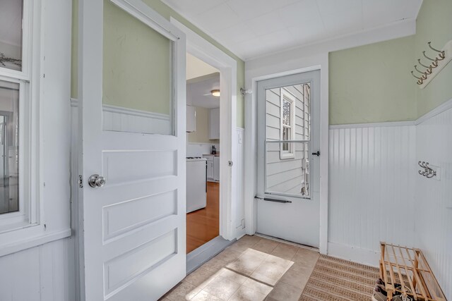 entryway with wainscoting and light tile patterned floors