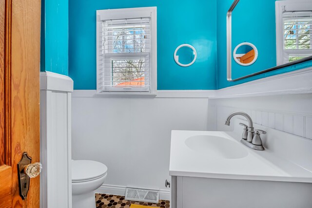 bathroom featuring visible vents, baseboards, toilet, and vanity