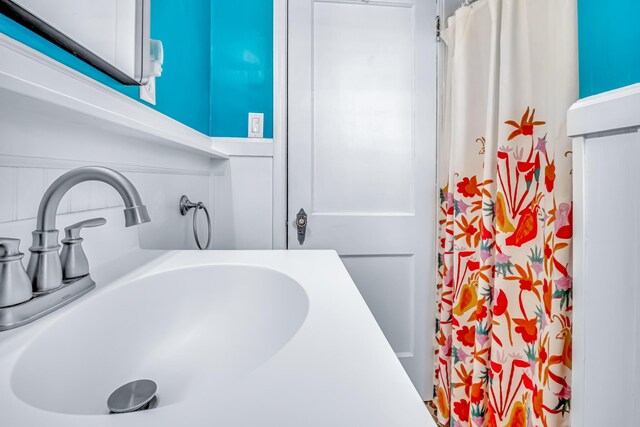 bathroom with a sink and curtained shower