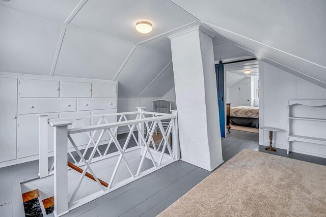 additional living space featuring vaulted ceiling and wood finished floors