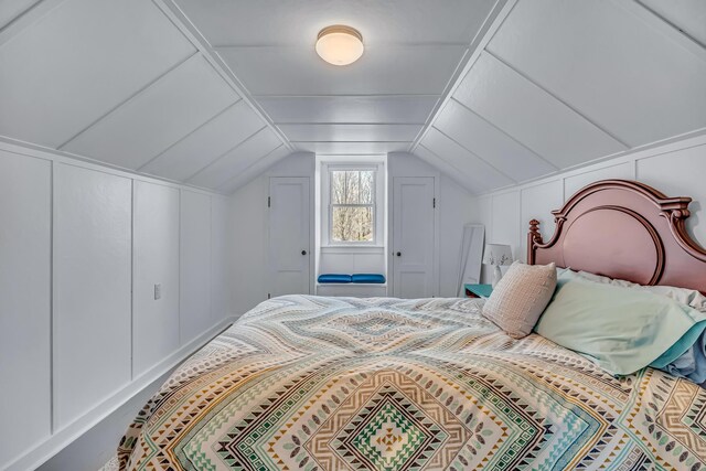 bedroom featuring a decorative wall and lofted ceiling