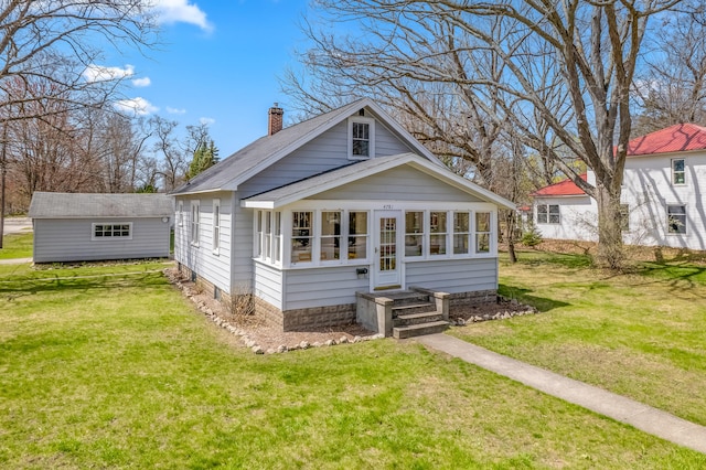 rear view of property with a lawn, a chimney, and roof with shingles
