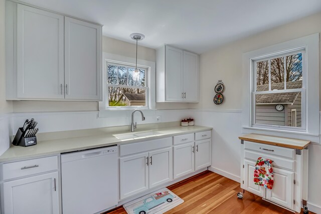 kitchen featuring a sink, light wood-style flooring, dishwasher, and a wealth of natural light