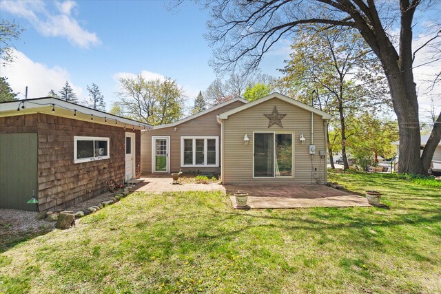 rear view of property with a patio and a yard