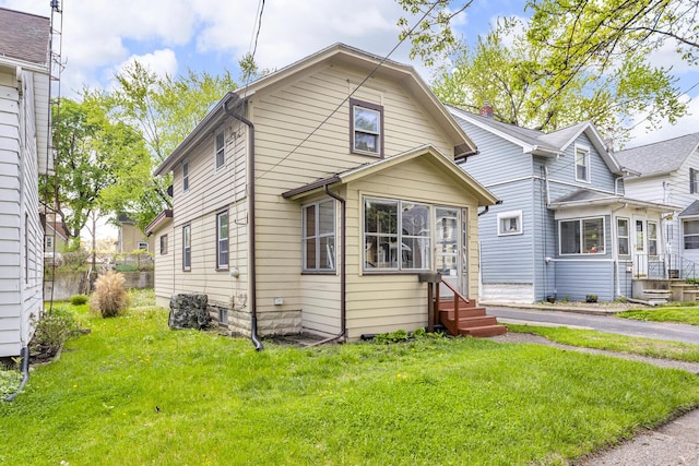 1319 Rhodes St, Jackson, MI 49202 - view of front of home with entry steps and a front lawn