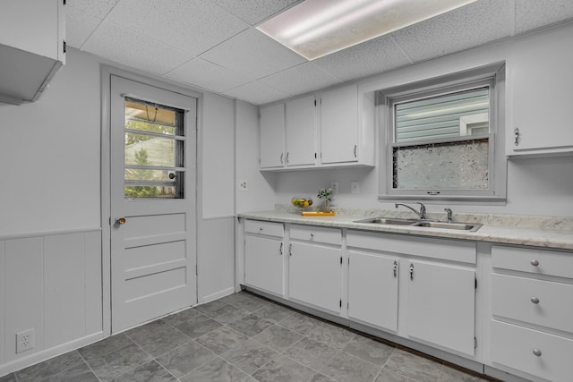 1319 Rhodes St, Jackson, MI 49202 - kitchen featuring a sink, white cabinets, and a drop ceiling