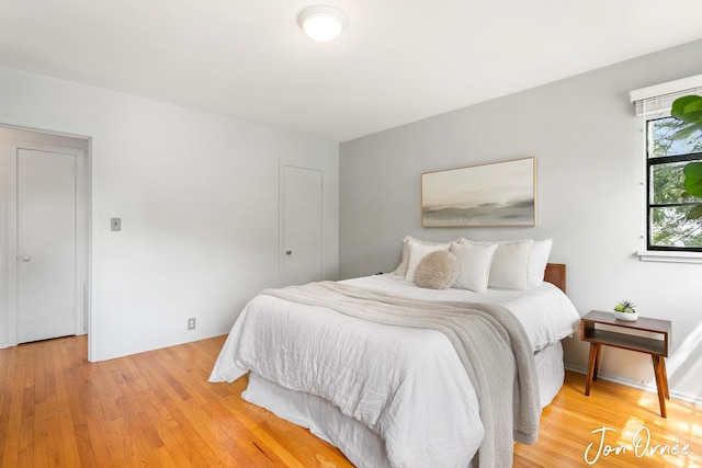 bedroom featuring baseboards and light wood finished floors