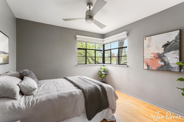 bedroom with baseboards, ceiling fan, and wood finished floors