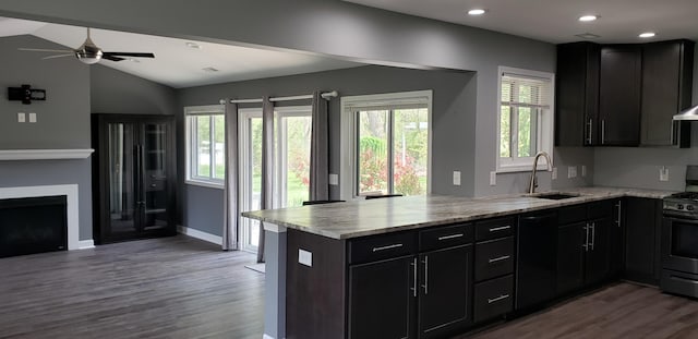 kitchen with gas stove, a sink, black dishwasher, a peninsula, and wood finished floors