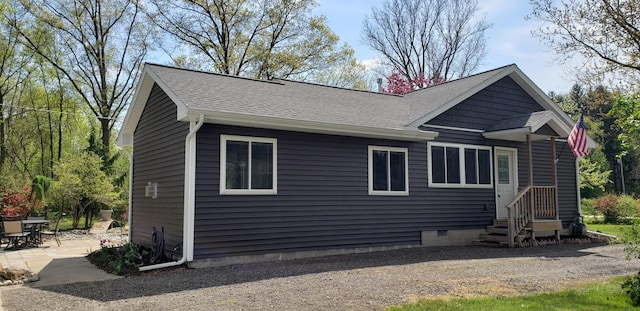 rear view of house featuring a patio and a shingled roof