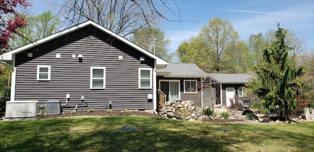 exterior space with central AC unit and a yard