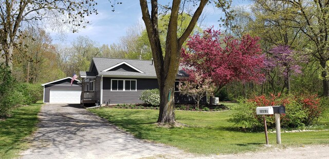 view of front of house with a garage, an outbuilding, and a front lawn